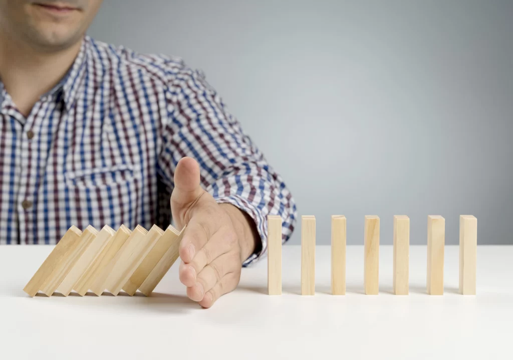 Hombre detiene la caída de bloques de madera enfiladas.
