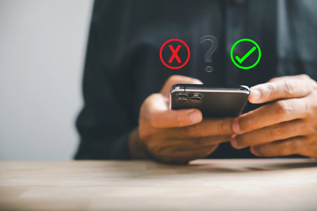 Teléfono sostenido por un hombre con dos opciones: una positiva y otra negativa.