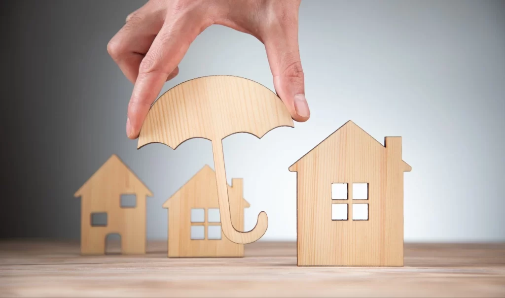 Casas y un paragüas de madera posicionados en una mesa.