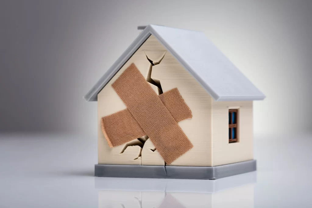 Maqueta de una casa destruida con curitas para su unión.
