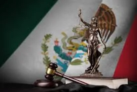 Figura de la justicia con la bandera de México de fondo.